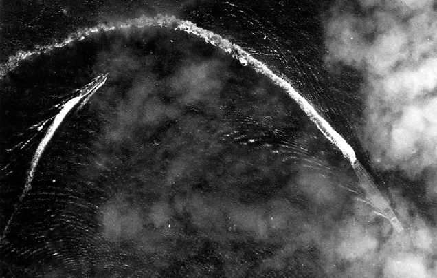 The Japanese carrier Akagi, trailed by a cruiser, turns to dodge the bombs dropped by American B-17s. (US Air Force)